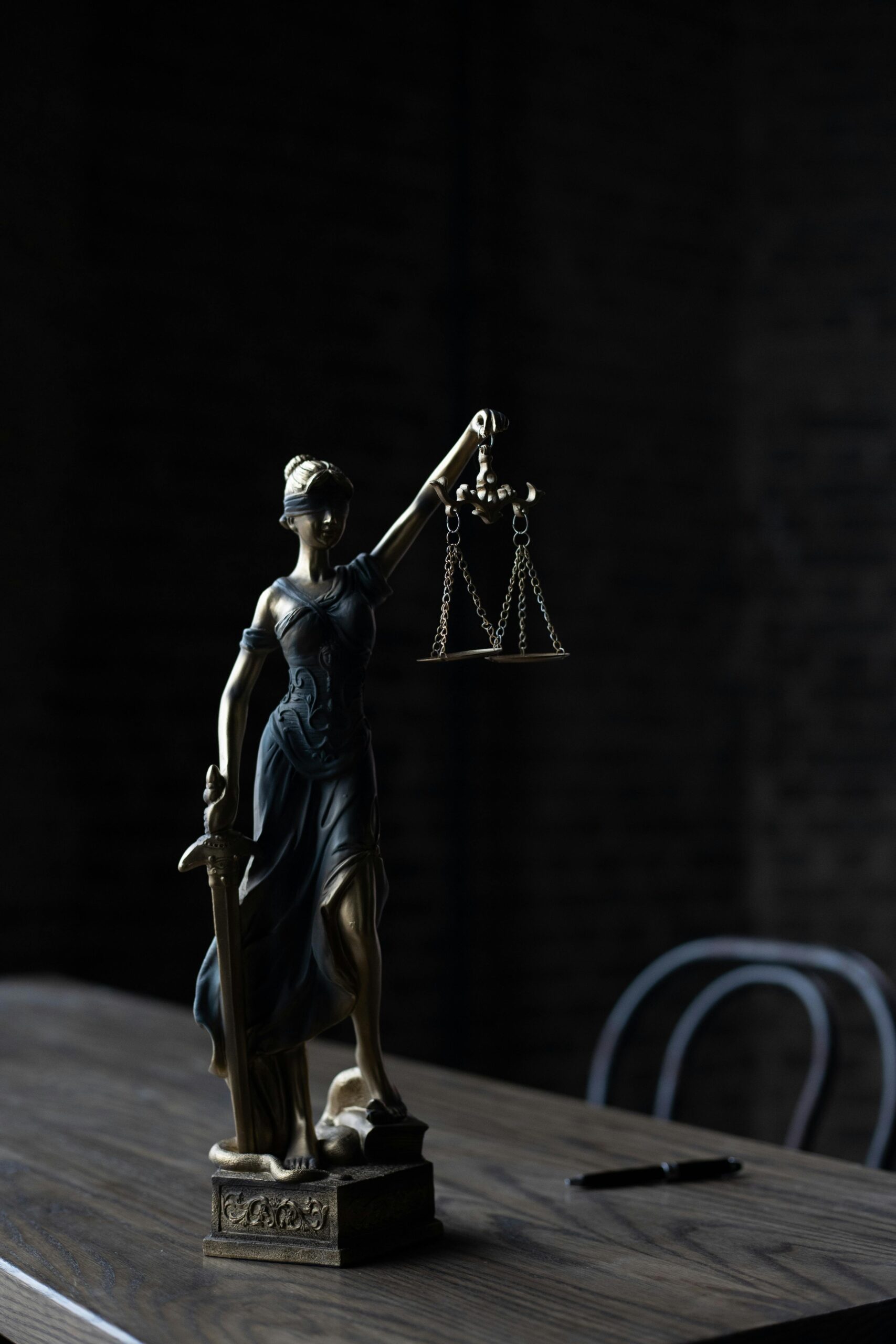 İLETİŞİM Dramatic lighting on Lady Justice figurine, symbolizing law and fairness.